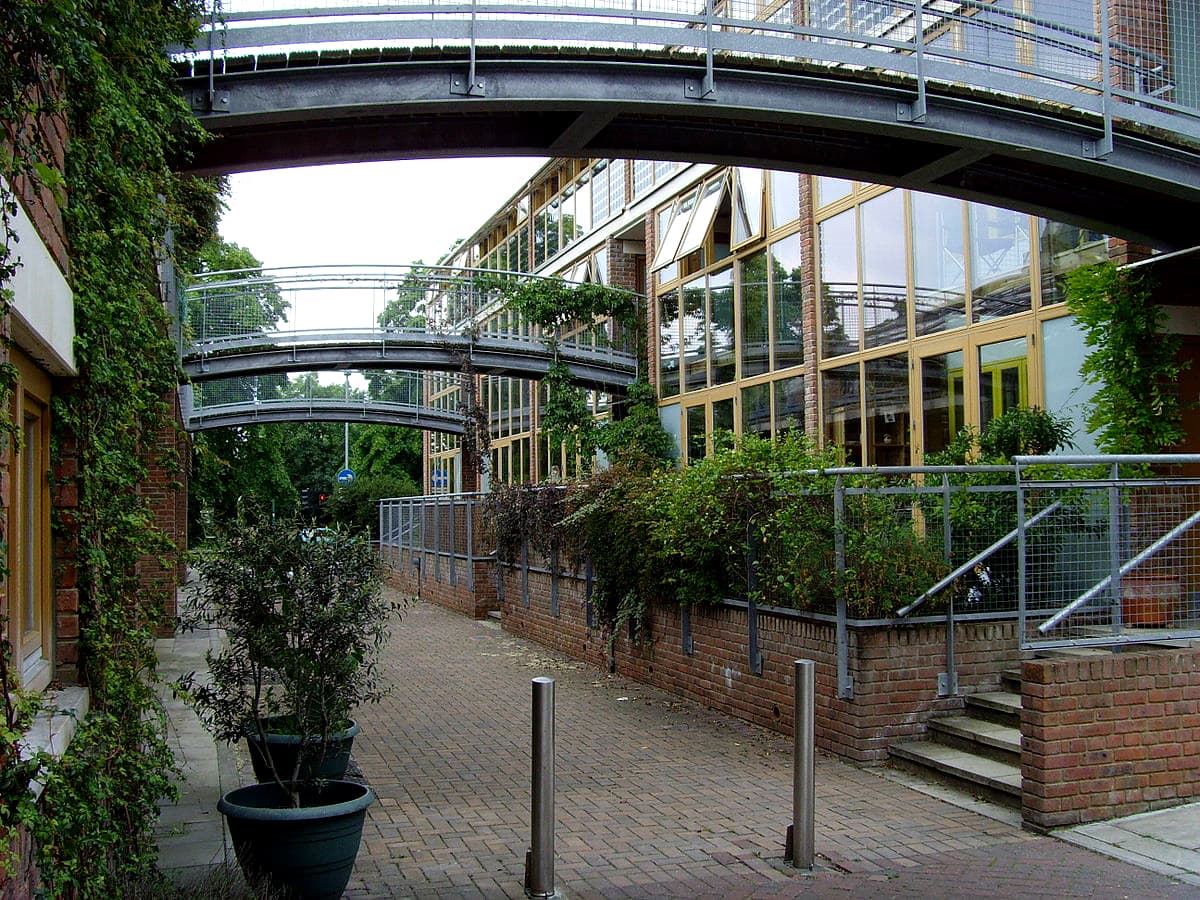 A pedestrian street lined with homes and colorful wind cowls at BedZED in South London.